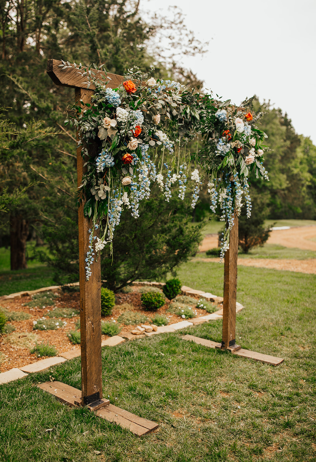 Ceremony Arch with Rust and Blue Florals at Cedarmont Farm