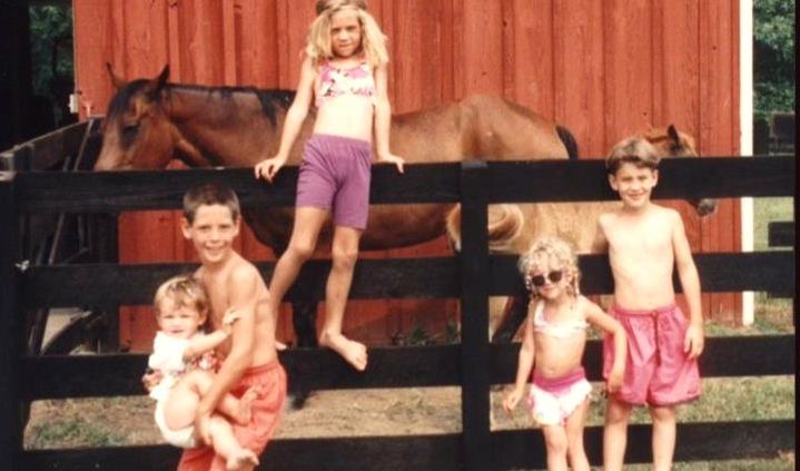 kids posing with a horse on estate property