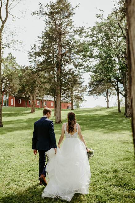 Bride and Groom walking towards barn wedding venue