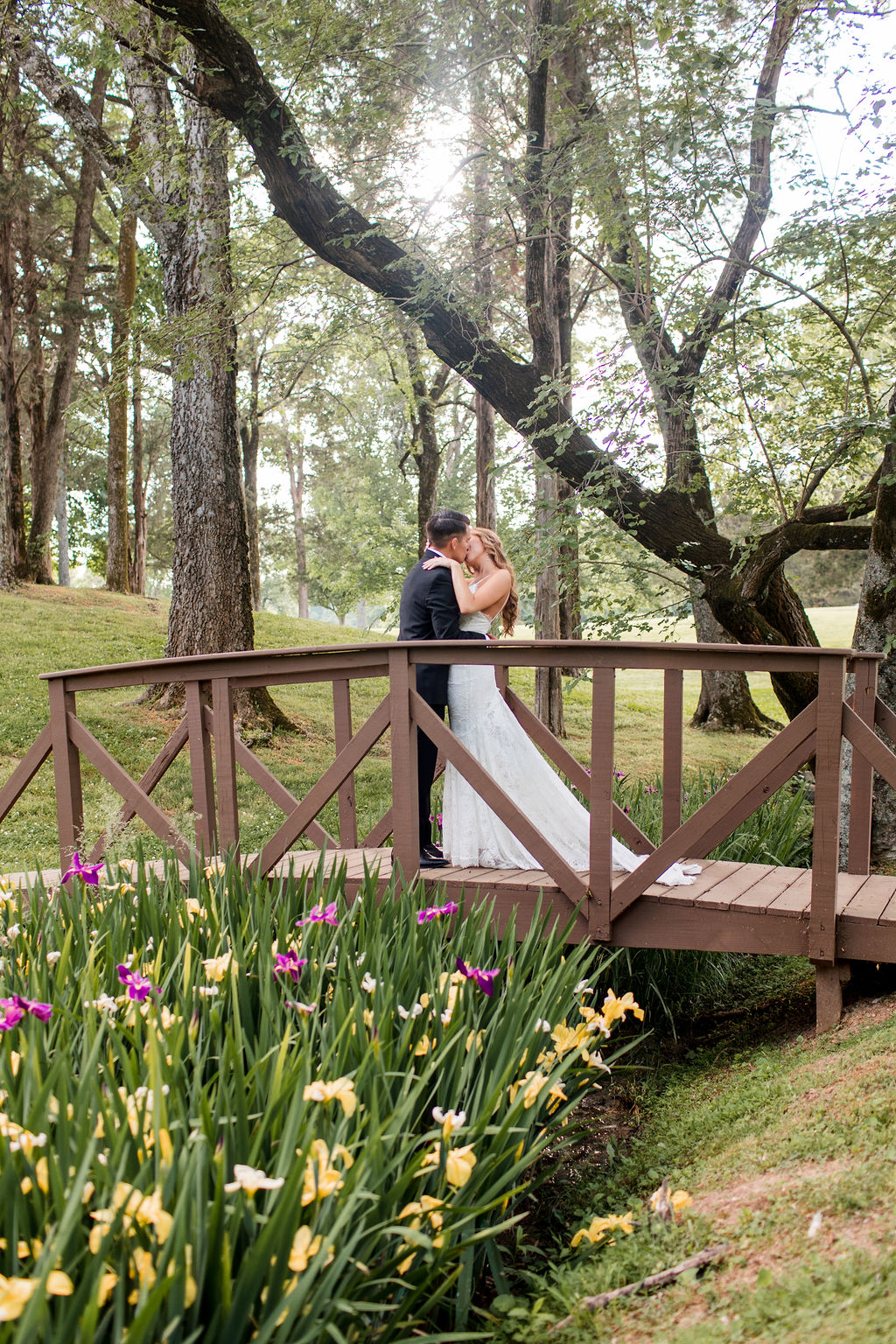 Couple kiss surrounded by trees at Cedarmont Farm wedding