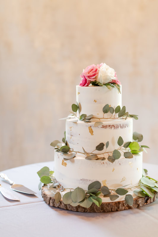 Bare iced wedding cake with gold flakes