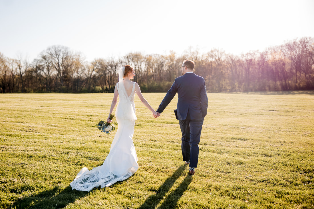 Nashville Spring Wedding Bride and Groom walking across field at Cedarmont Farm 