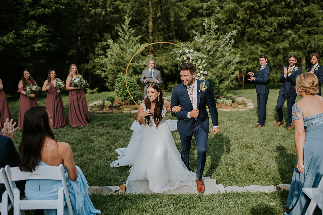 couple recess down aisle at outdoor wedding ceremony