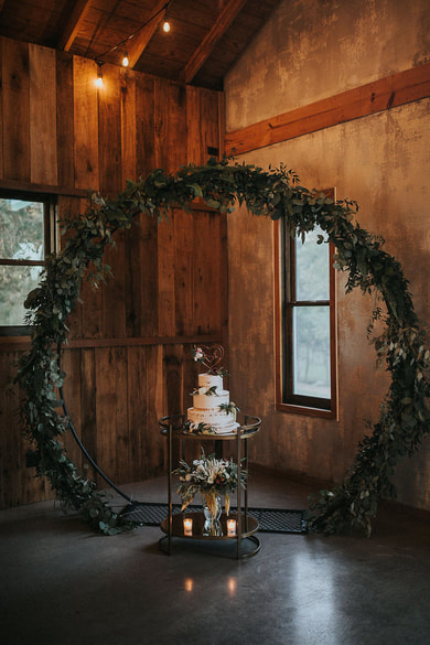 wedding cake on display in rustic wedding barn
